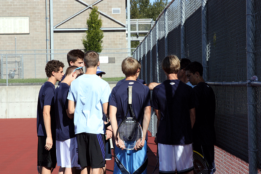 The boys varsity tennis team huddles to talk strategy.