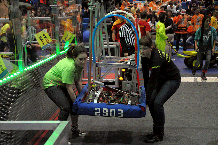 Sophomore Elizabeth Burnham and Senior Caroline Vogl carry the robot off the court at the Girls’ Competition on Saturday Oct. 18th.