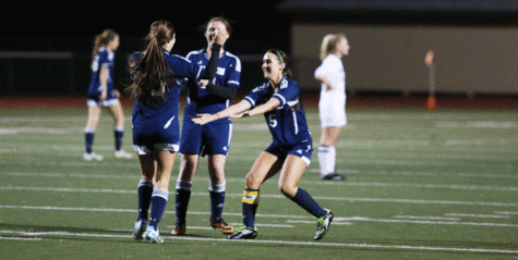 Jillian Busby (12) and Courtney Arnold (10) embrace Danielle Baker (11) to congratulate her after scoring her third goal, finishing a hat trick. The first of the three goals was Baker's first of the season