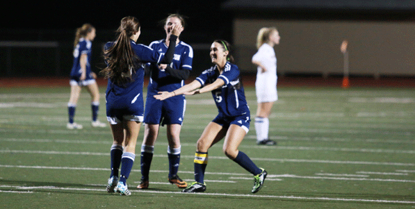 Jillian Busby (12) and Courtney Arnold (10) embrace Danielle Baker (11) to congratulate her after scoring her third goal, finishing a hat trick. The first of the three goals was Bakers first of the season