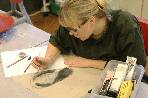 Olive Walton (10) works on a charcoal piece during Art Club