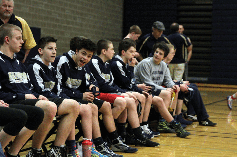 Varsity wrestlers sit on the sidelines prior to a wrestling meet at Arlington High School on January 29. 