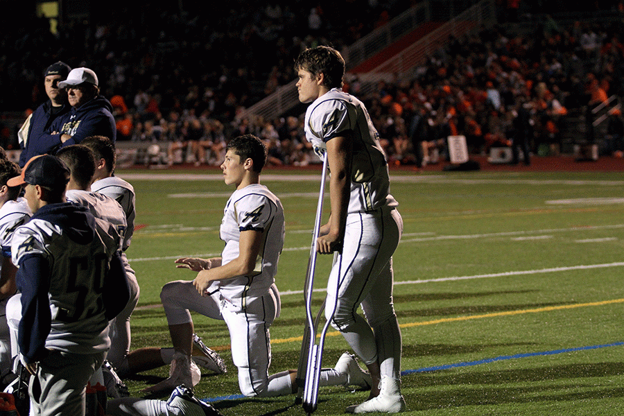 Kyler Smith (16) and Kyle Bayer (16) listen to Coach Dailers half time speech after sustaining injuries in the first half of the game against Eastside Catholic. 