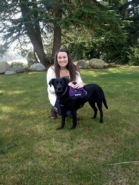 Grace Meno (16) poses with her service dog, Abby. 