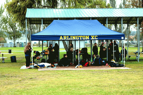 Some of the Eagle cross country runners stay dry and warm under their tent at City Beach Park in Oak Harbor on October 8.  