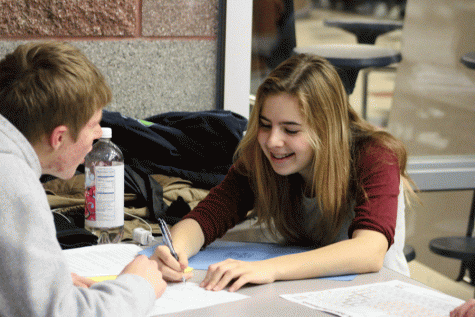 Senior Lily Bynum and junior Nicholas Mendro complete their physics homework before the Knowledge Bowl Match on December 8th. 