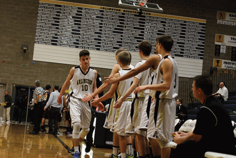 Sophomore Campbell Hudson high-fives his teammates after coming off the court during a game against Oak Harbor on January 12th.