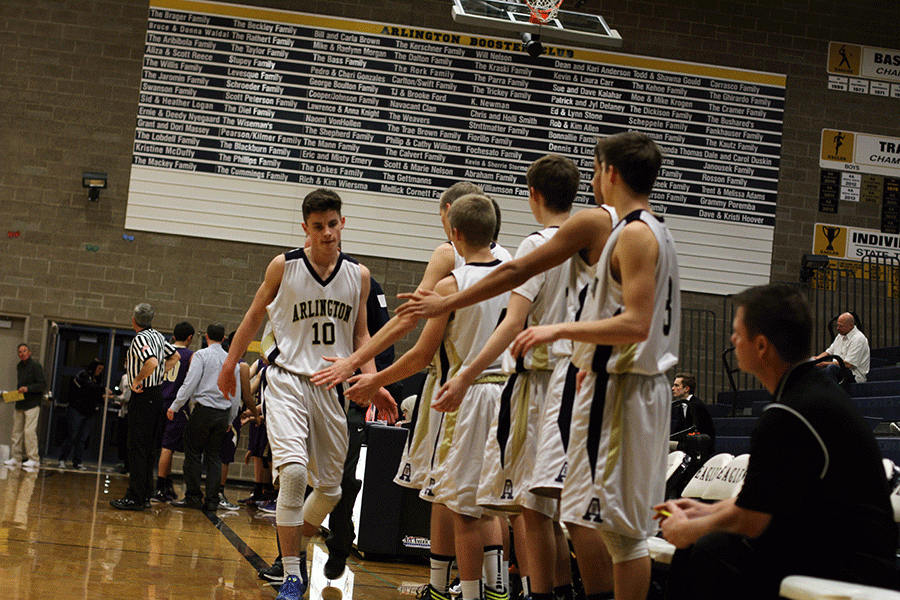Sophomore Campbell Hudson high-fives his teammates after coming off the court during a game against Oak Harbor on January 12th.