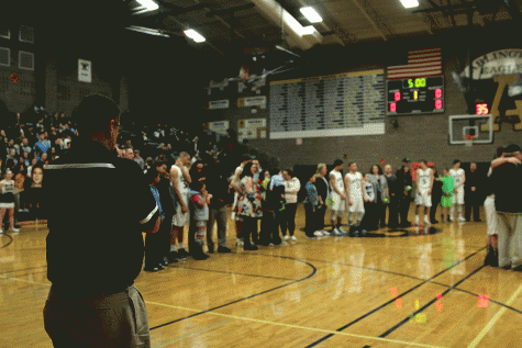 Arlington Boys Basketball Head Coach Nick Brown watches as his 8 seniors are honored prior to the Eagles victory over Everett. 