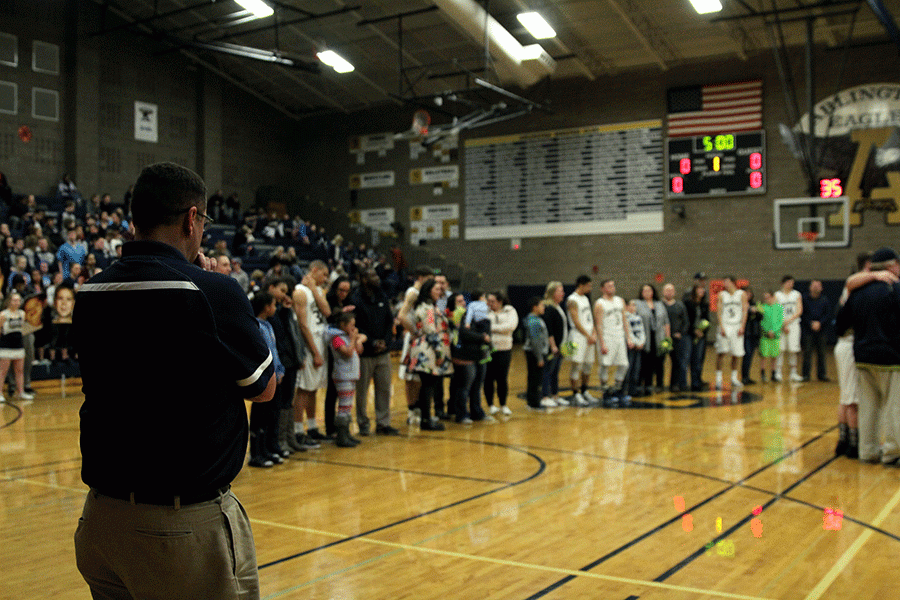 Arlington Boys Basketball Head Coach Nick Brown watches as his 8 seniors are honored prior to the Eagles victory over Everett. 