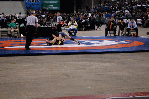 Ruben Crew attempts to pin his opponent in the 3A State Championship match. Crew went on to win the match and become just the second state champion from Arlington. 