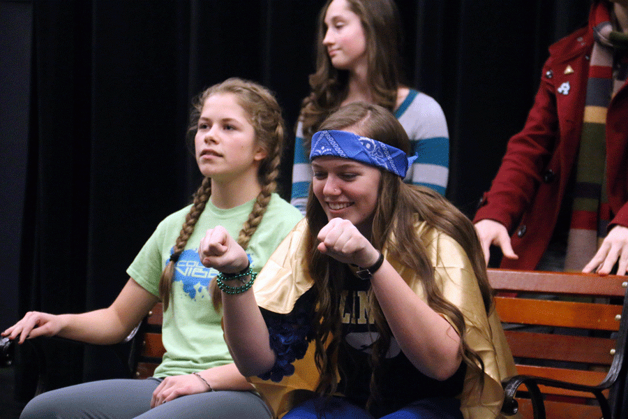 Delaney Pickard (17) and Hannah Glunt (18) acting like they are driving a car during a drama club meeting.