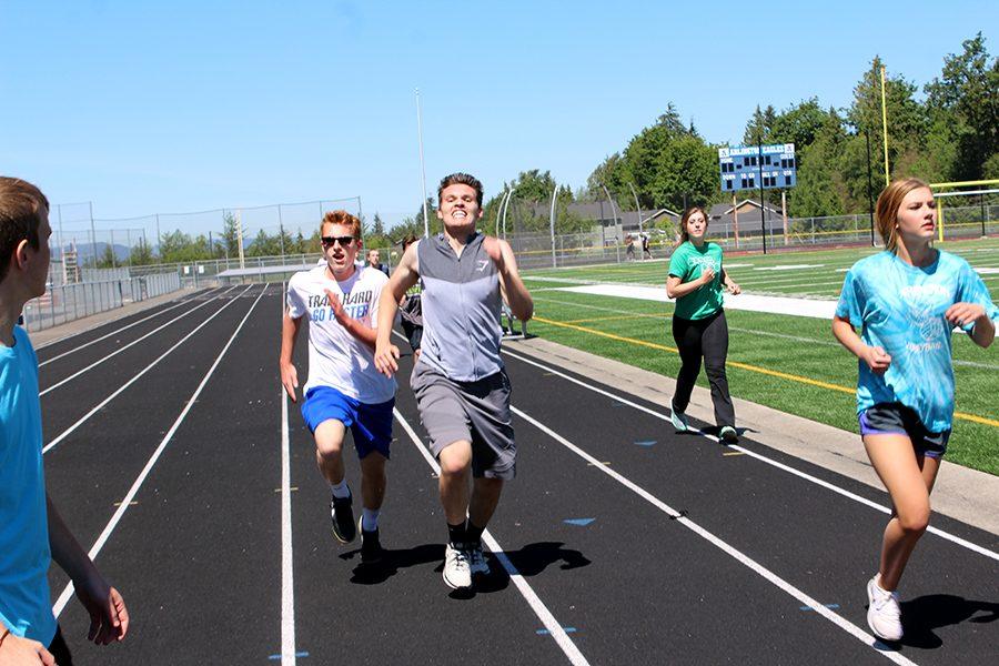 Borees Kargopoltsev (16) passes Braeden Mauch (18) during the PE mile.  Pushing through pain and winning a race is  one example of individual accomplishment.