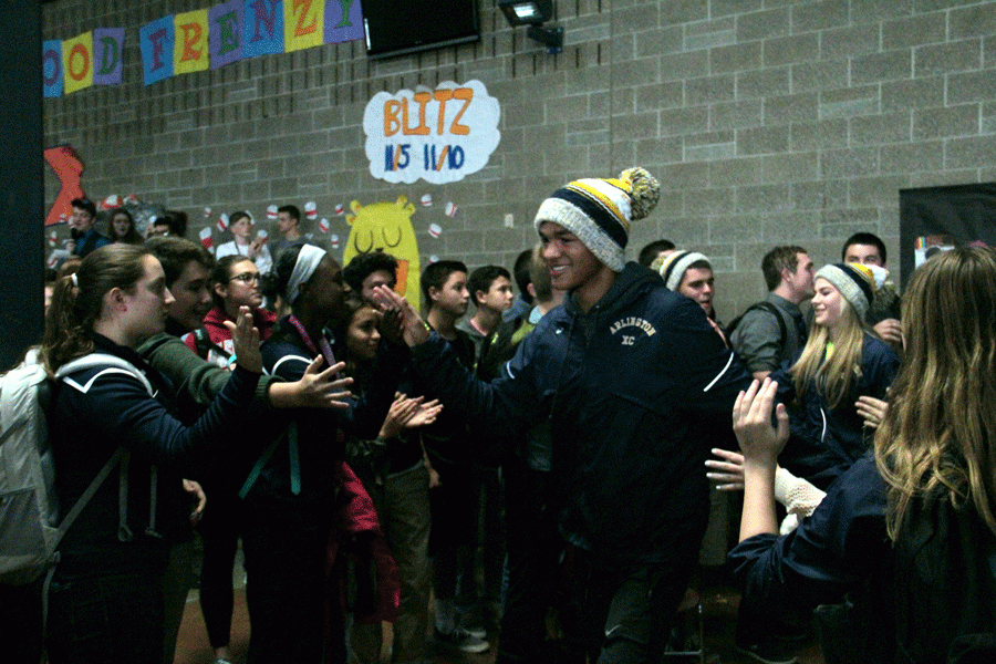 Kevin Mullin (17) high fives his peers walking through the commons during the cross country state send off.