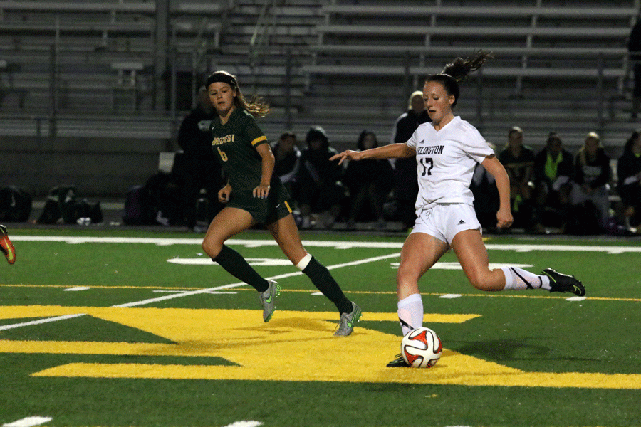 Jamie Farrar ('17) takes on a Shorecrest defender and plays a through ball to her teammate.