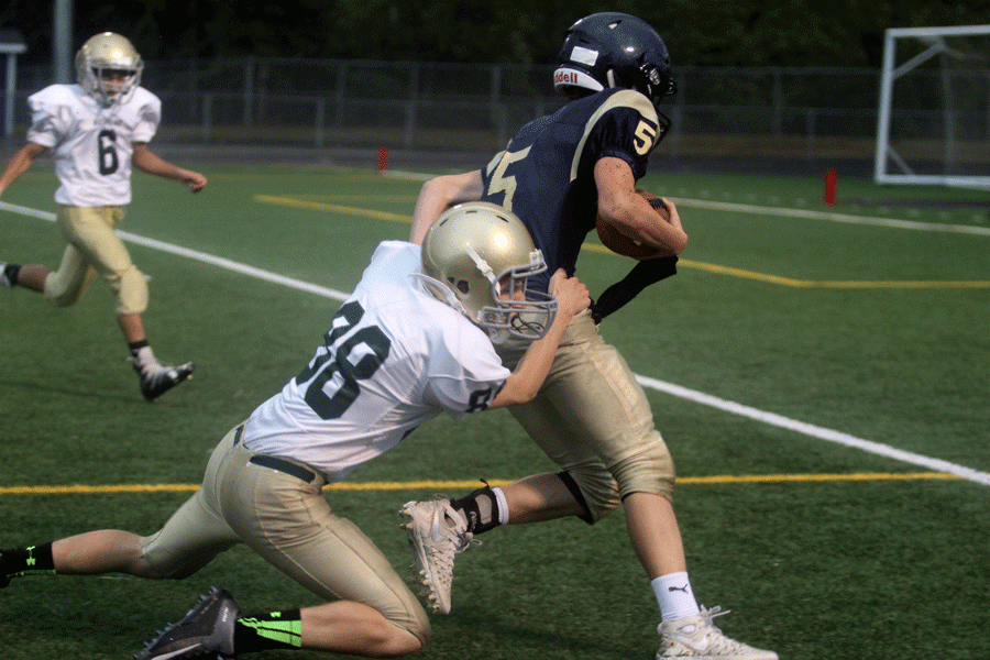 Colby Williamson (20) catches the ball and fights his way towards the end of the field. 