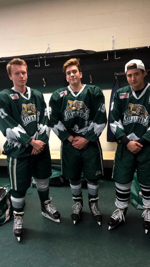 Jeffrey Andrews (‘19) poses with two of his teammates in the locker room at Everett Comcast Arena before a game. Andrews plays for the Everett Jr. Silvertips.