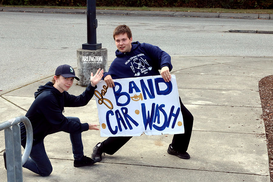 The AHS band holds an annual car wash in the high school parking lot to help raise funds for their activities. Jacob Hurst ('20) and Gavin Gray ('18) hold signs to advertise to the community about the event.