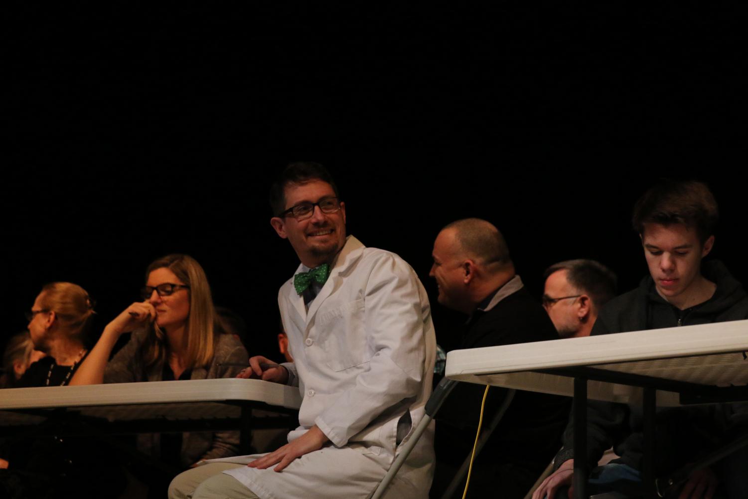 Mr. Berg eagerly awaits for his team's turn to answer during the students vs. teachers game.
