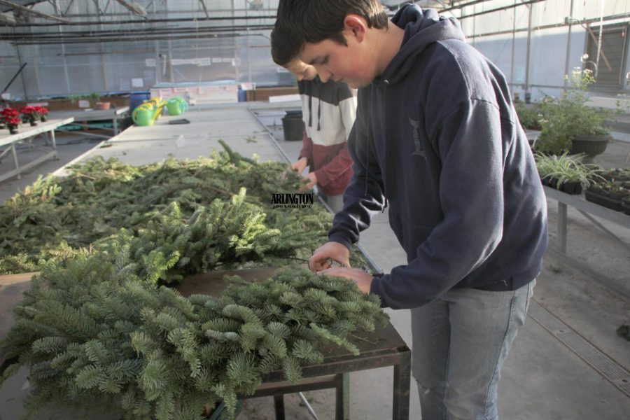 Simon Fuentes, 10th Grade, is creating a wreath for the FFAs club fundraiser.