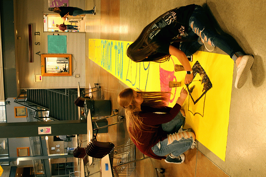 Jackie Stupey (12) and Halle Peterson (10) paint the Welcome sign for Senior Tea. 