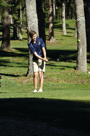 Junior, Nate Metcalf, chipping onto the green at Glen Eagle Golf Course during a home match.