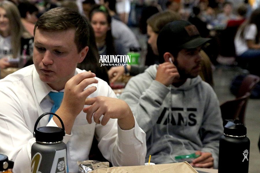 Kirahy Meyers (12) sits eating lunch in his fancy attire.  