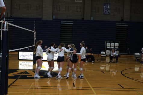 Junior-Varsity volleyball girls come together in between points and keep motivating one another. 