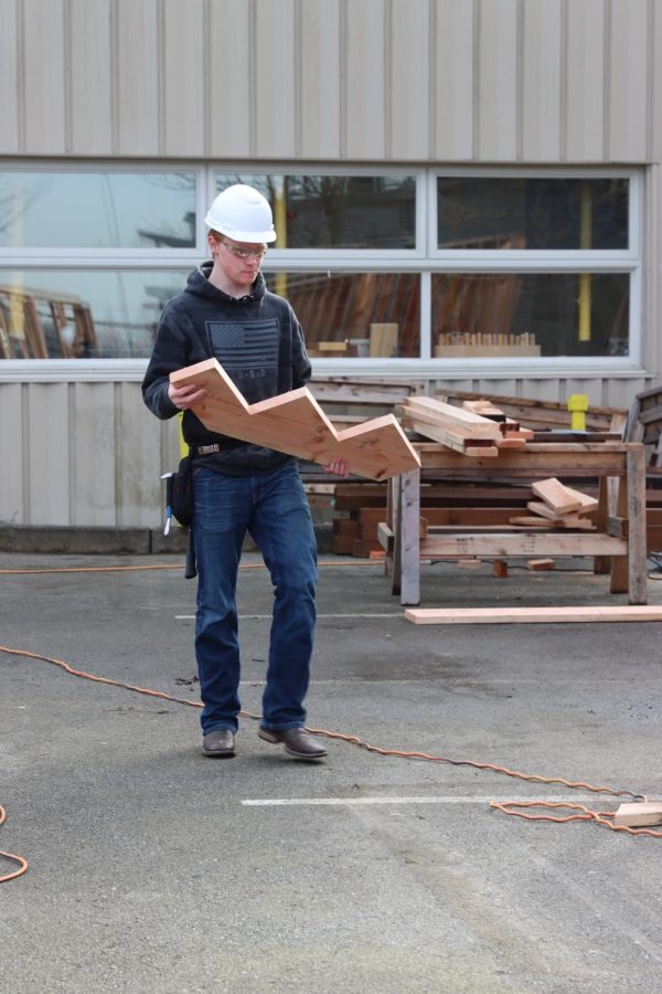 A student is seen carrying a wooden piece during a Skills USA Competition on Jan. 27. 