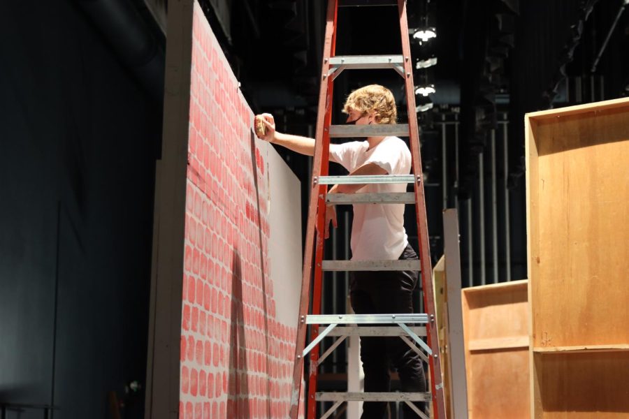 Riley Bauer (22) is assembling a set for the All In the Timings theatre production on Oct. 18.