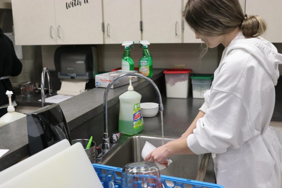 A student is seen cleaning dishes in culinary class on March 21. 