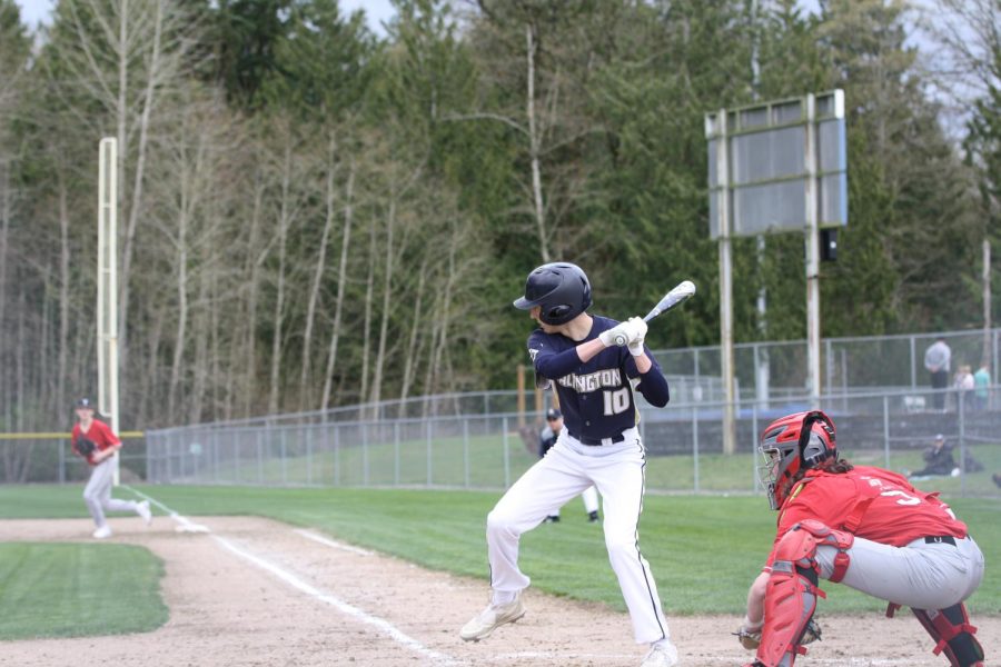 A member of the varsity boys baseball team is seen batting at a game on March 29, 2022. 