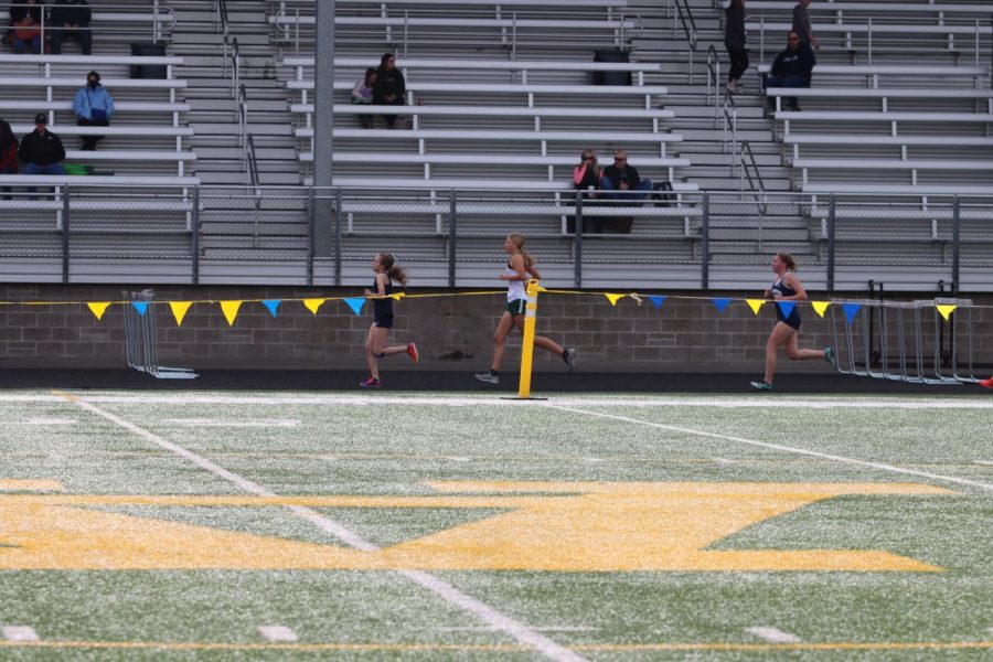 Members of the girls track team are seen running at a meet on March 24, 2022. 