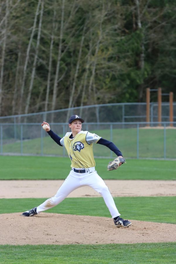 A member of the varsity boys baseball team is seen pitching at a game on April 1, 2022. 