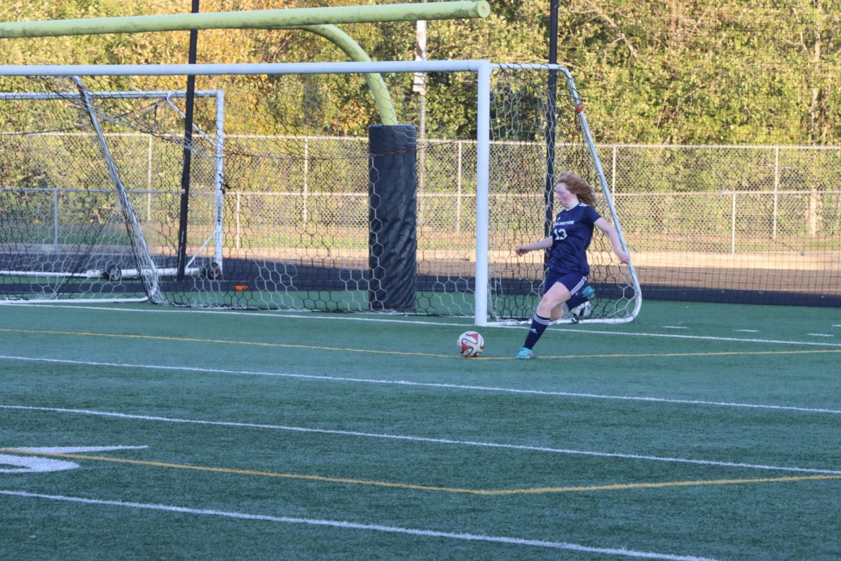 Madi Moore (25’) aims to kick the ball down the field to advance the ball.