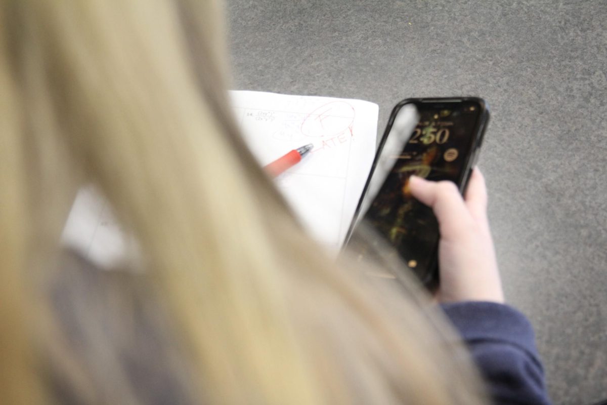 Student distracted by phone instead of  doing schoolwork