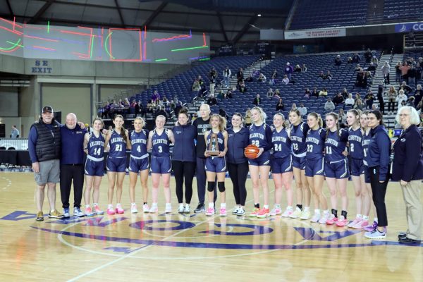 Coach Marsh poses with his team and coaching staff to celebrate a 5th place finish at the 2024 State Basketball tournament