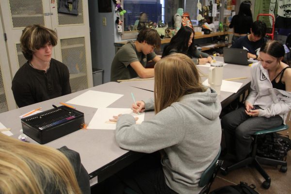 Students working on their art history projects in Ms Rose's classroom on Halloween.