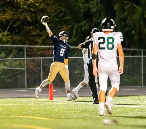 Dylan Durfee ('26) scores a touchdown on a sliding grab, and shows the referee the ball.