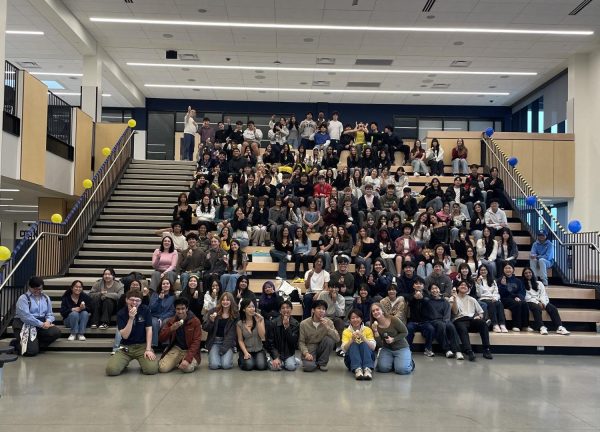 At a district council meeting, Key Club poses for a photo after coming together to donate food supplies collected for the Key Club district project, End Youth Homelessness.