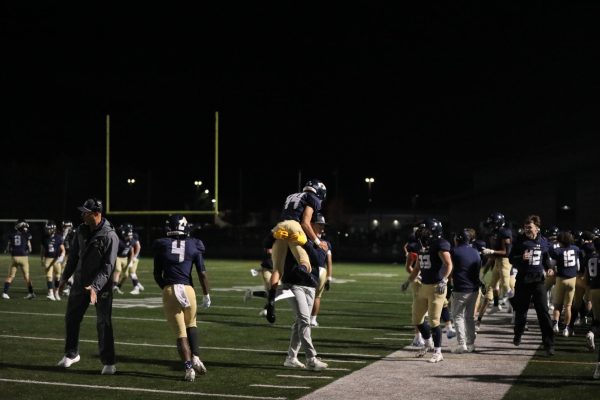 Kicker Mason Mendoza ('26) celebrates with QB/DB coach Blake Petersen after Arlington makes it a single score game.