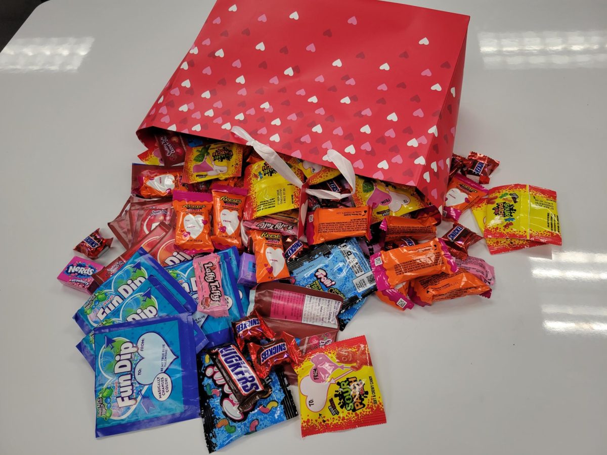 Candy spilling out of a bag on a desk.