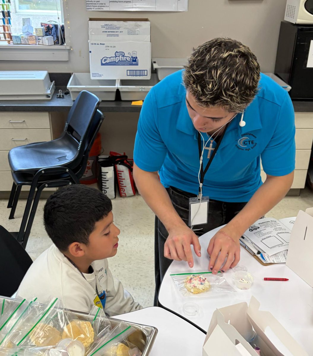 Dezra Guerrero helping a student during the culinary stop 