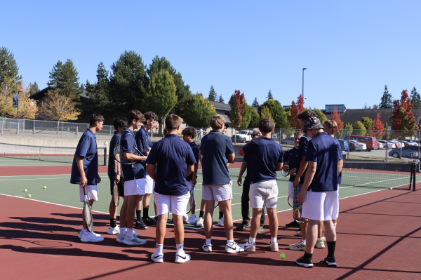 This photo is of Mendro (Tennis Coach) having his team in a huddle before they disperse  into their matches.